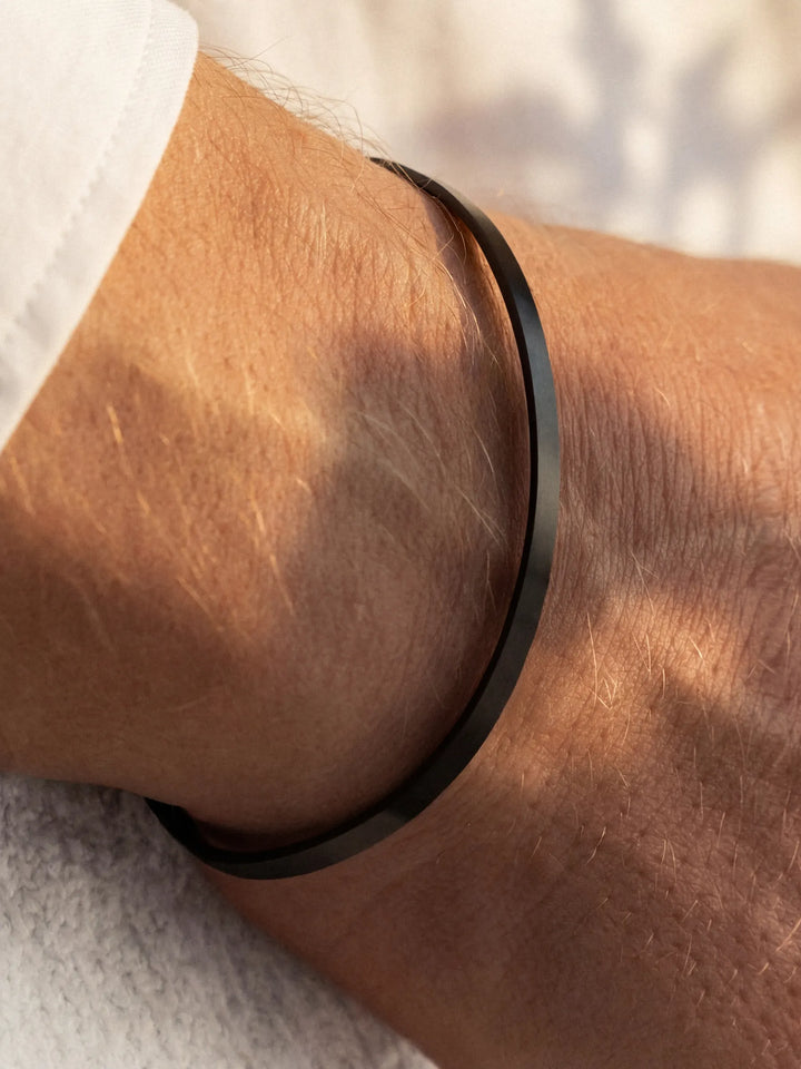 Black cuff on a wrist with a blurred background