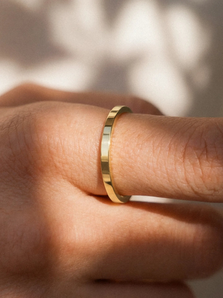 Gold ring on a finger with a blurred background